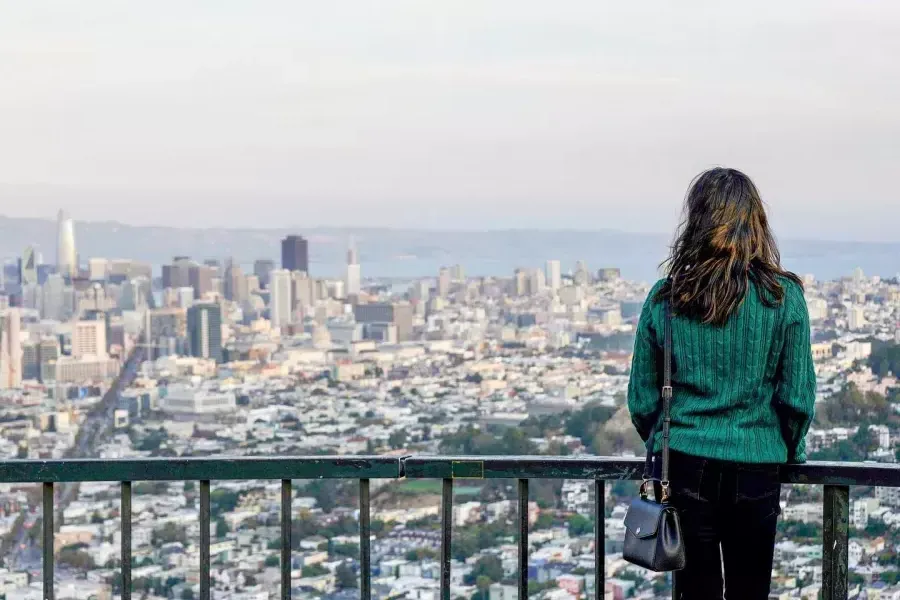 A woman looks at the San Francisco skyline from Twin Peaks.