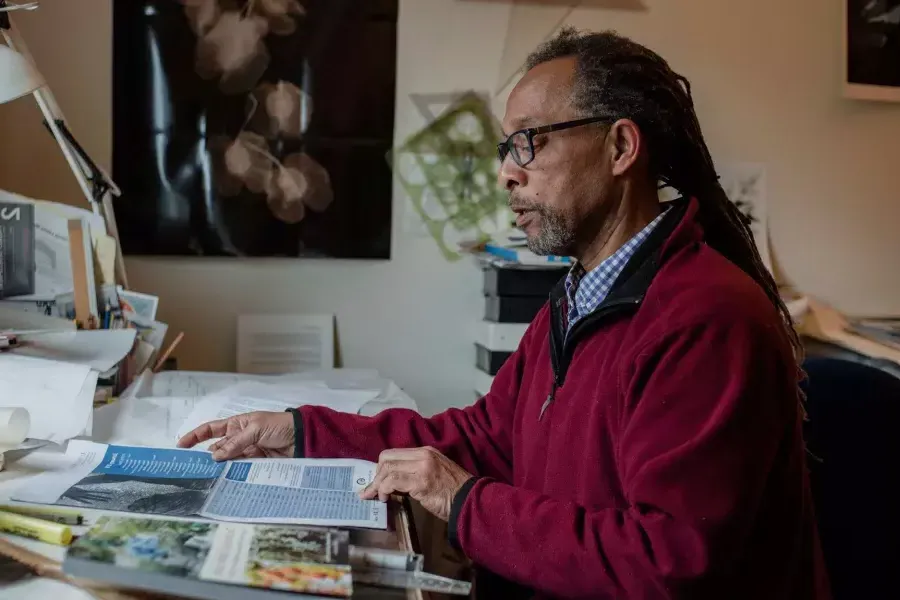 罗恩·莫特里·桑德斯 sitting at his desk reading