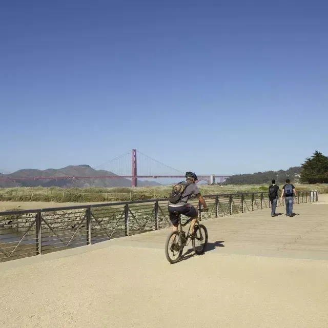 A man rides a bike along a trail at Crissy Field. San Francisco, California.